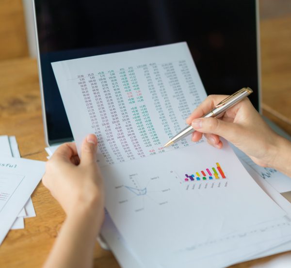 Business woman hand with Financial charts and laptop on the table